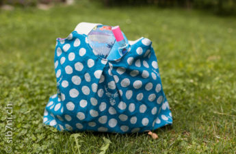 Badetasche Milly türkis, bepackt mit Badeanzug, Badetuch, Schnorchel und Taucherbrille und Ball